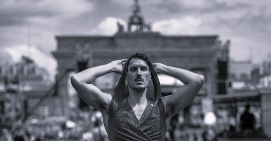 A person in a glitter dress outfit standing in front of the Brandenburg Gate in Berlin.